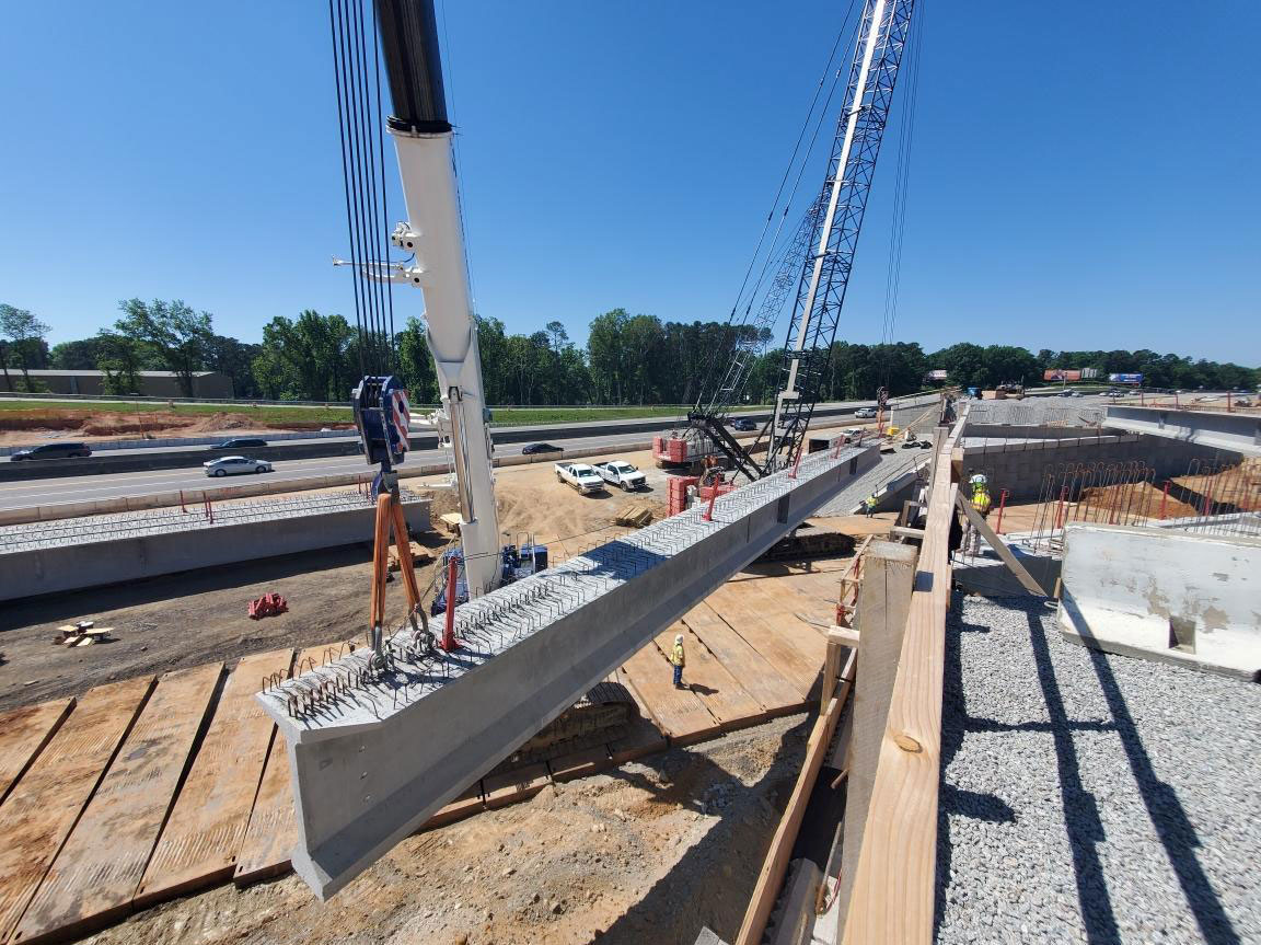 Crane operators working in unison to place the concrete girders for the new bridge. 